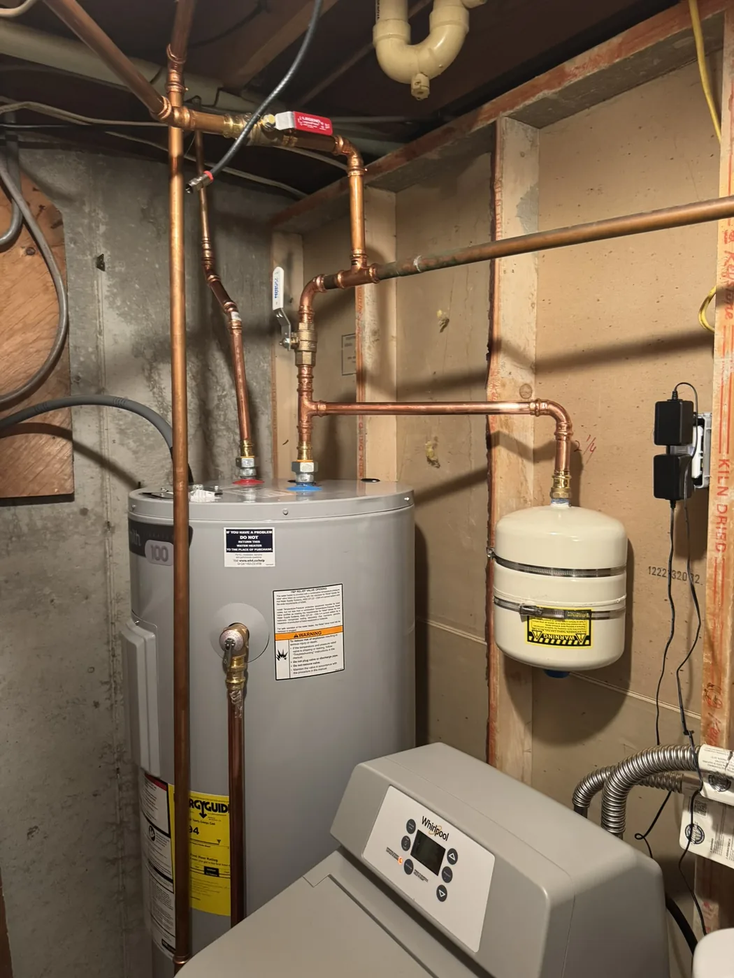 AO Smith electric water heater installed beside a Whirlpool water softener